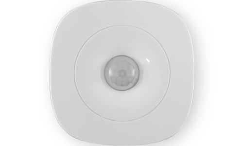 A white squircle shaped plastic device with a round PIR sensor in the middle